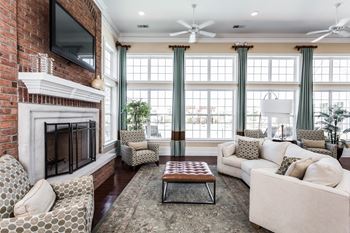 a living room with a brick fireplace and a couch and a coffee table at Brickshire Apartments, Merrillville, IN, 46410